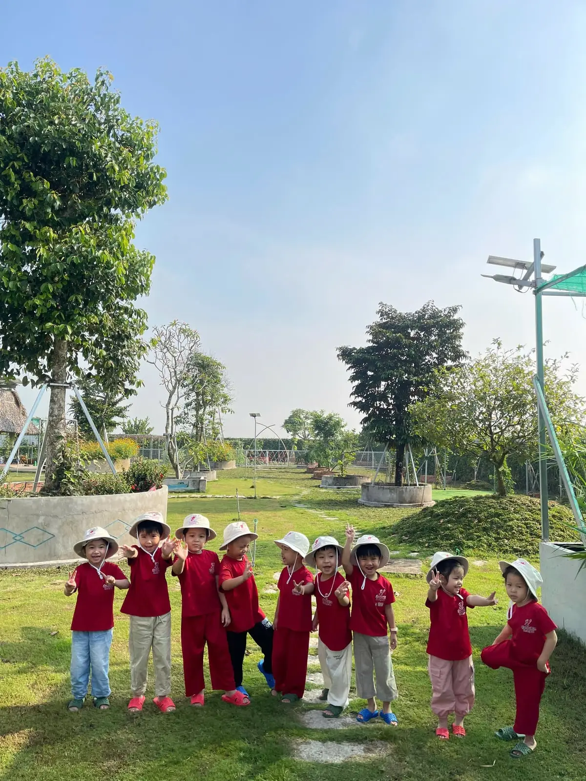 Các bé đội nón vải đứng hàng chụp ảnh giữa vườn JumboKiz Farm