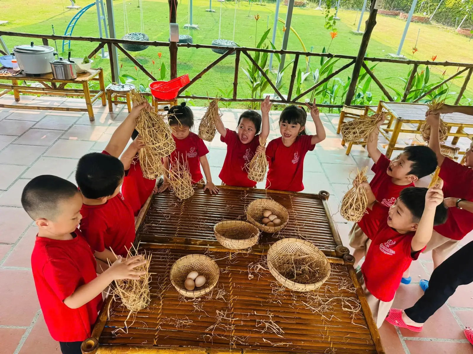 Các bé giơ ổ rơm khoe bên rổ trứng gà ở JumboKiz Farm