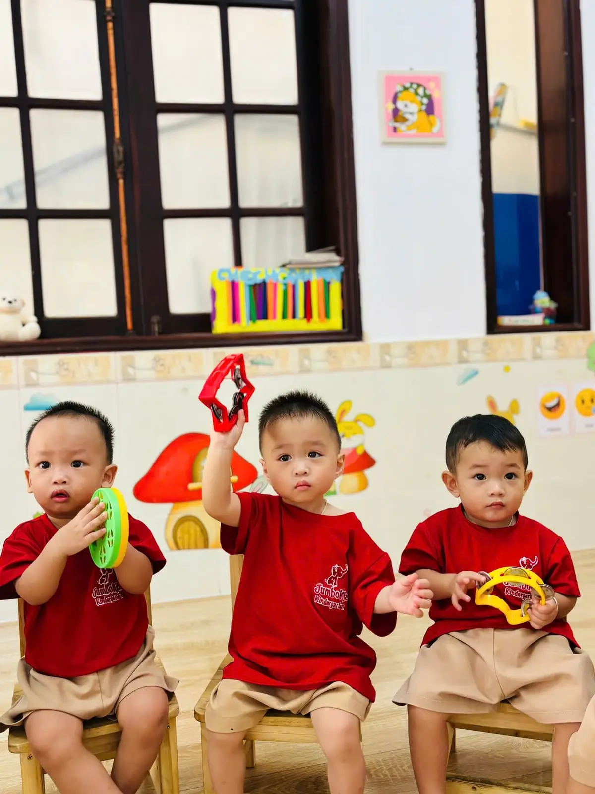 Ba bé trai lớp PreK1 lắc trống lục lạc trong giờ hát Jumbo Language