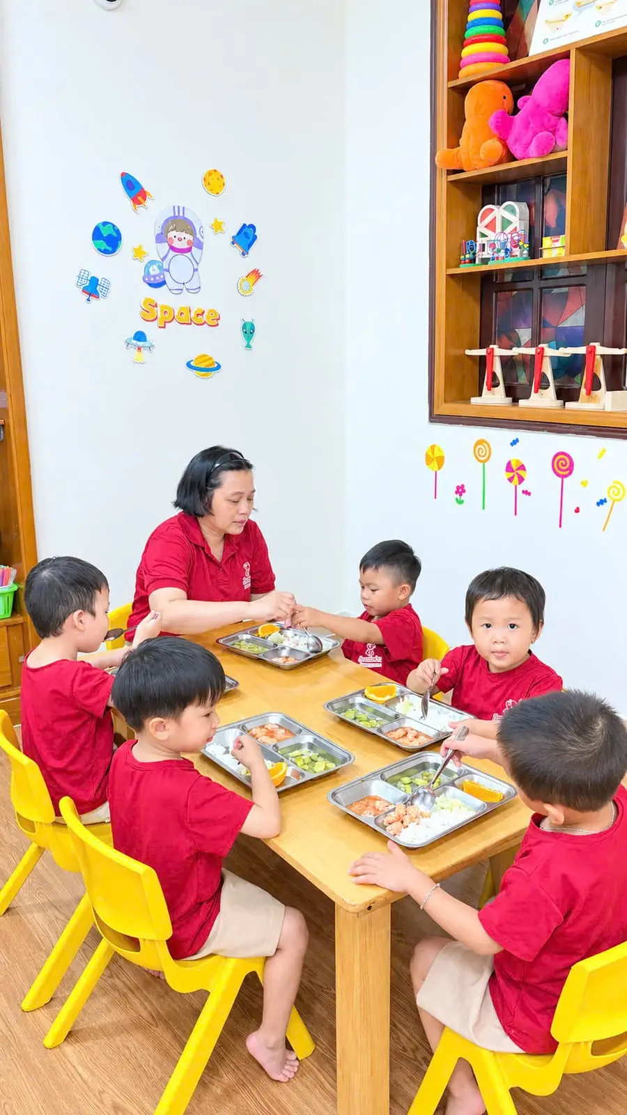 Cô giáo ngồi cùng bàn ăn trưa với nhóm bé trai
