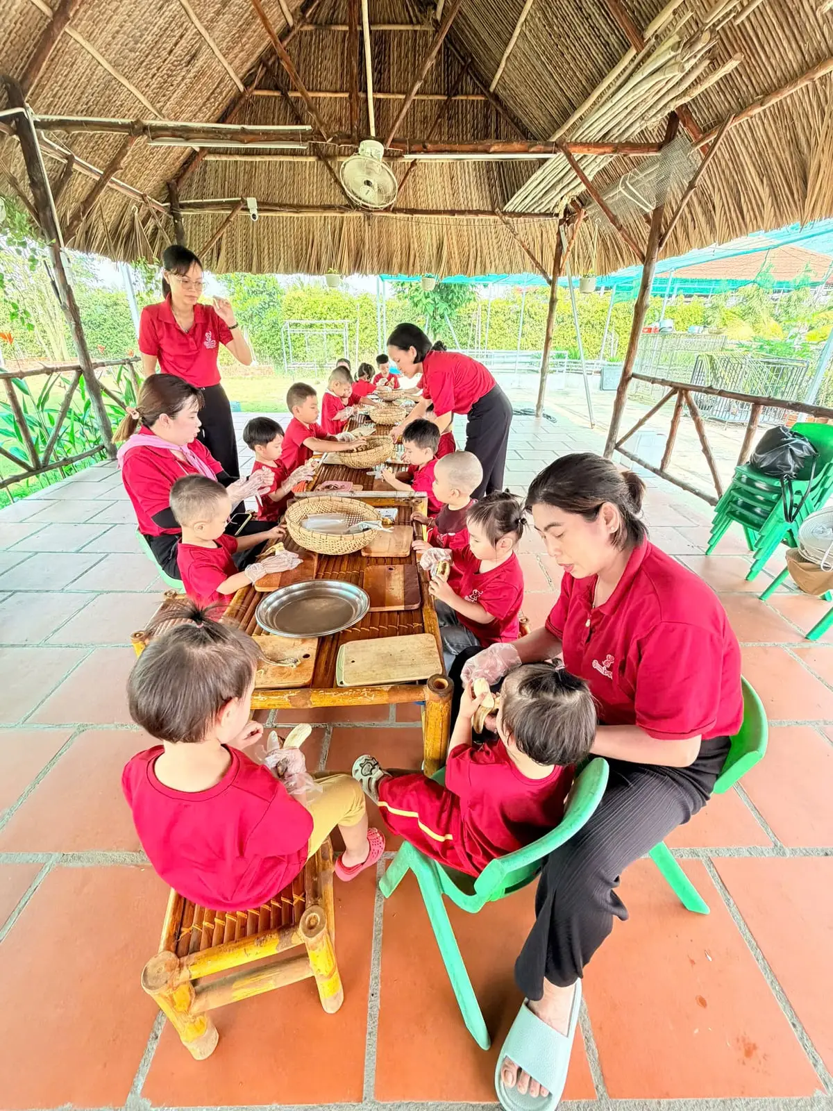Các cô cùng các bé ngồi bàn tre làm hoạt động dưới chòi lá ở JumboKiz Farm