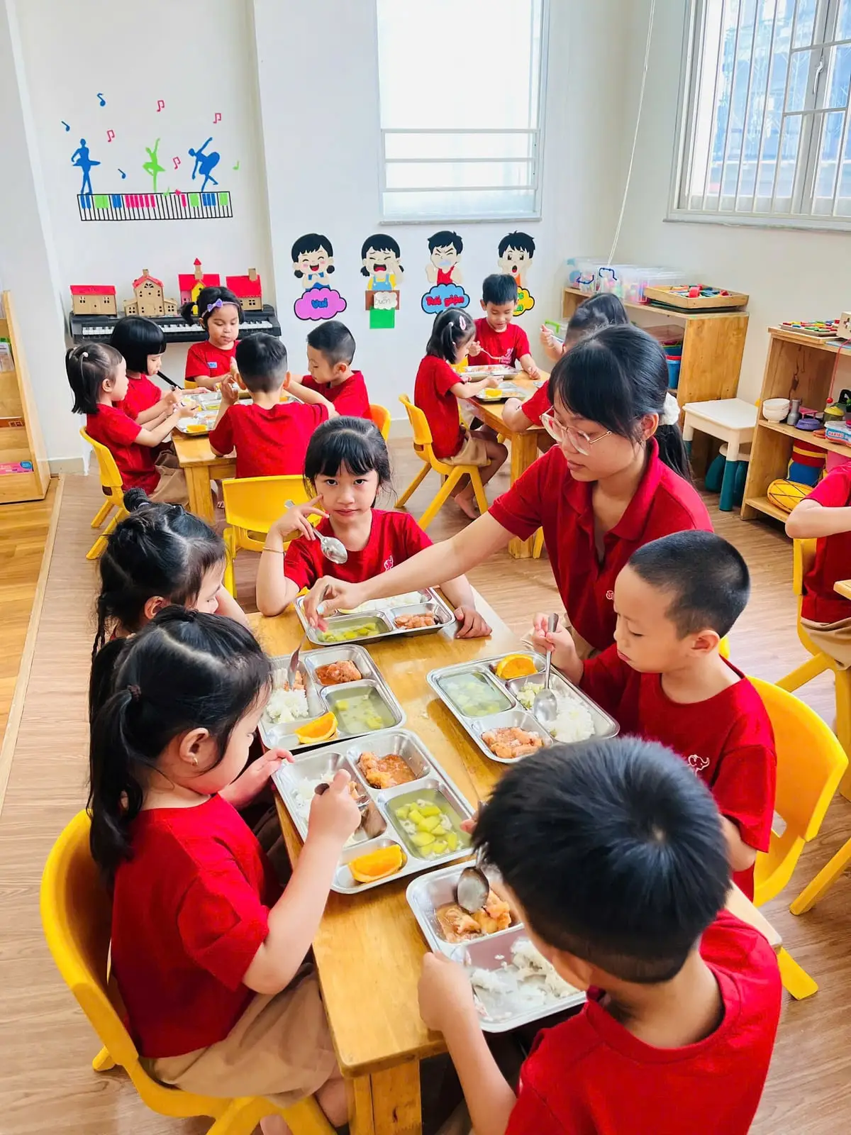 Cô ngồi cùng bàn, cả lớp tập tự xúc ăn khay cơm trưa đủ món